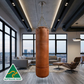 Brown leather punching bag hanging in a modern living room with large windows and cityscape view.