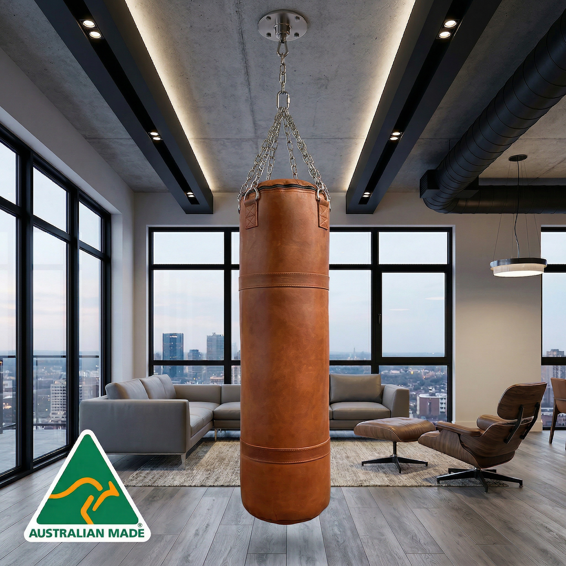 Brown leather punching bag hanging in a modern living room with large windows and cityscape view.